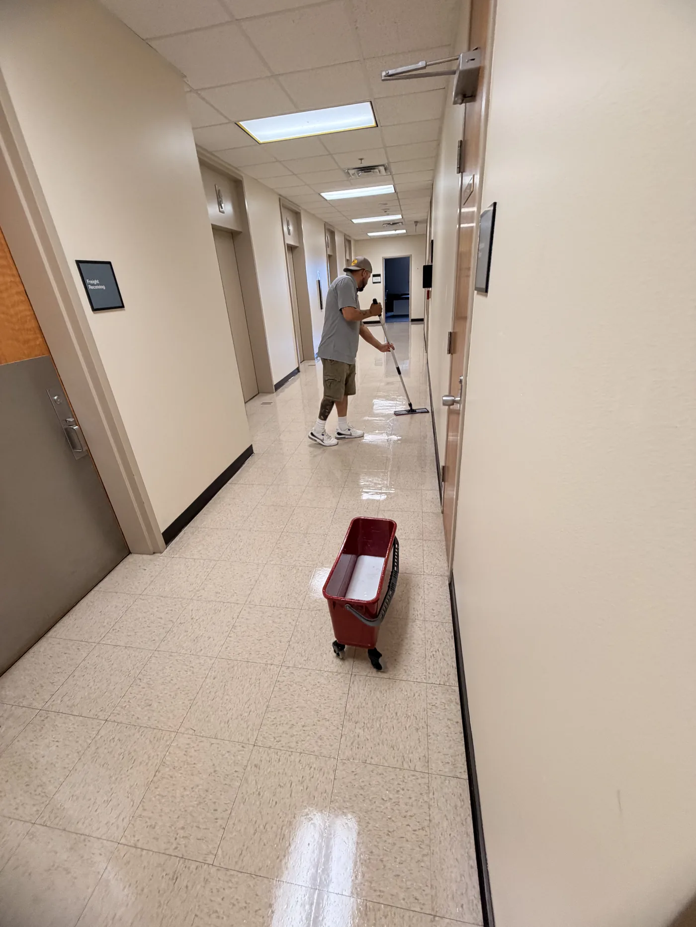 Mopping a facility corridor on a nightly janitorial route