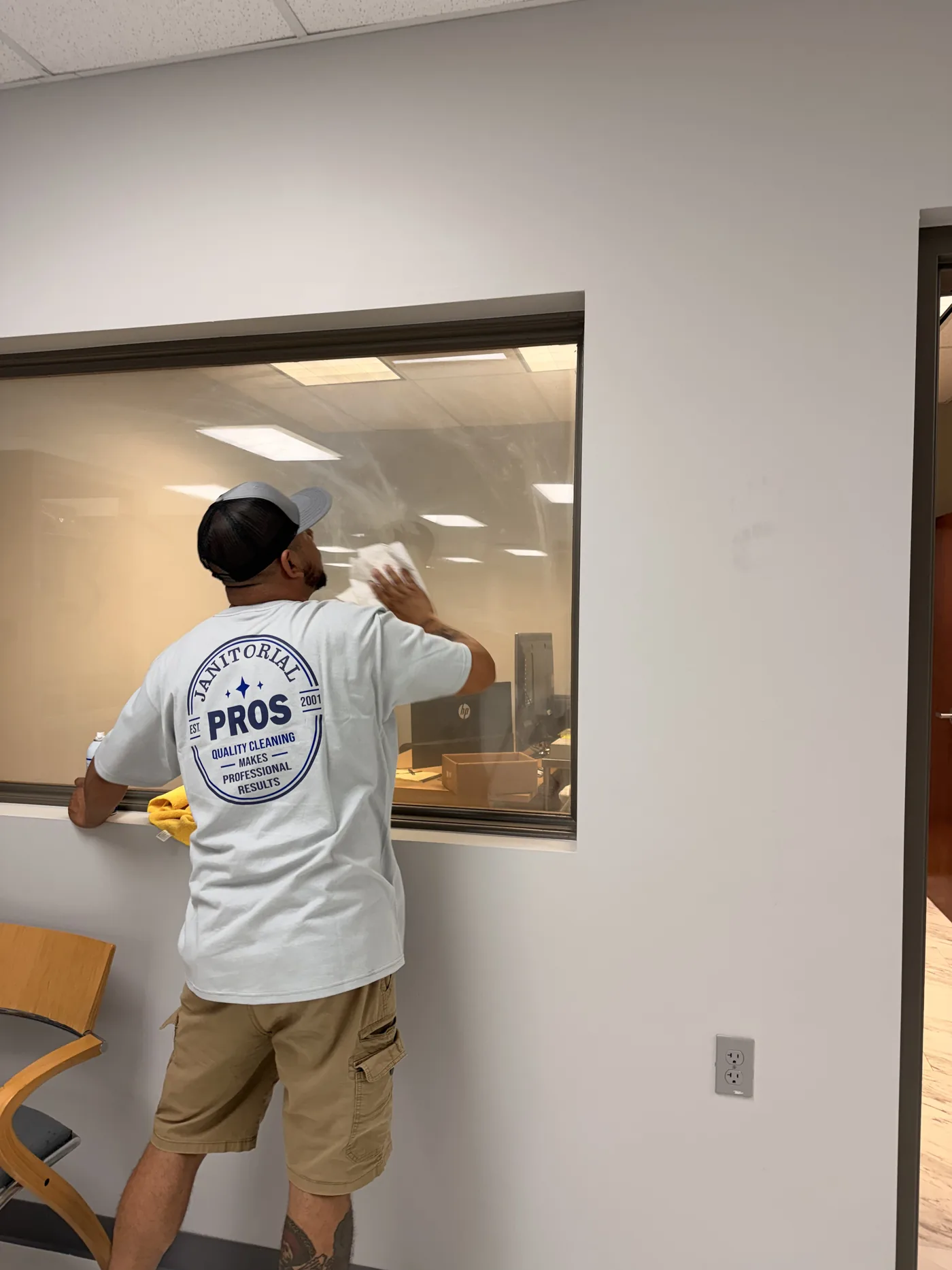 Cleaning interior glass in an office, Janitorial Pros crew